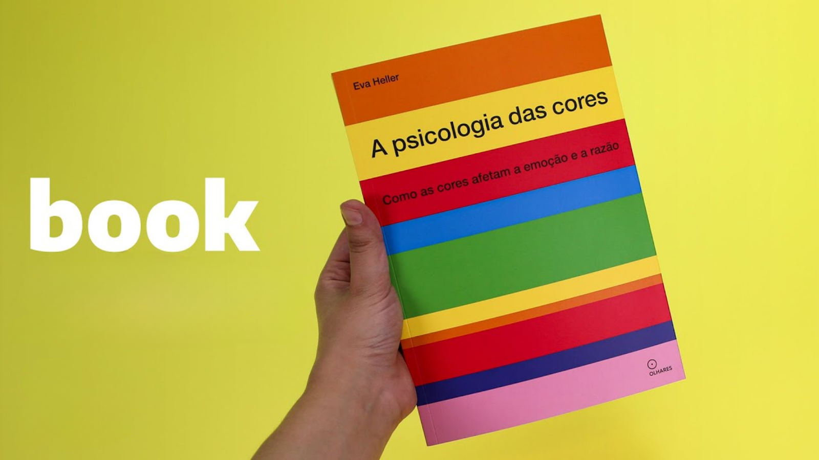 Imagem de um livro sobre psicologia das cores sendo segurado por uma pessoa – O estudo sobre como as cores afetam emoções e decisões é essencial para o design e o marketing.