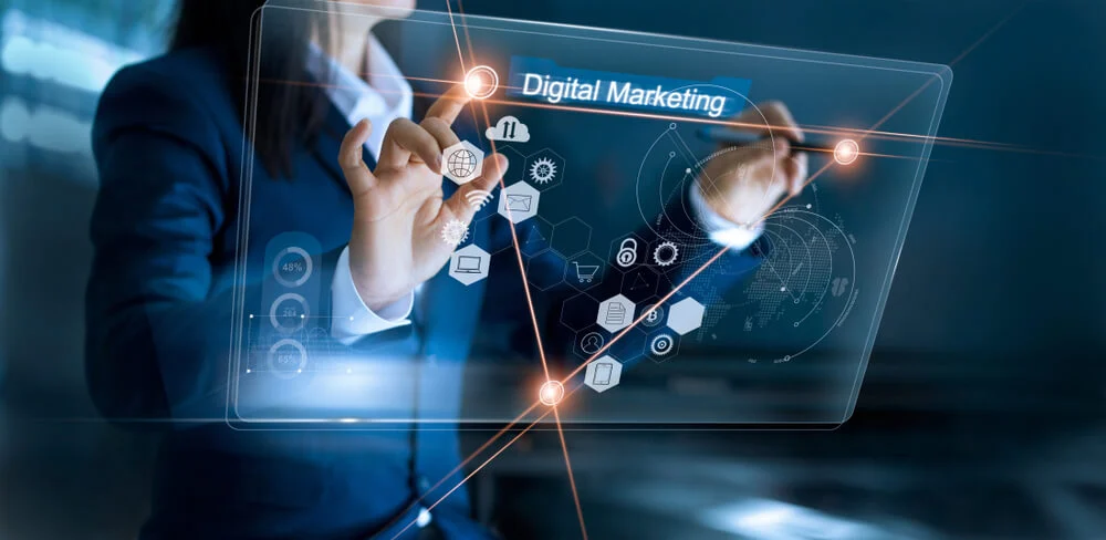 O que é Marketing Digital? Manual para Iniciantes 4 Uma pessoa interage com um tablet, onde aparecem diversos ícones representando elementos do Marketing Digital , como SEO, e-commerce, redes sociais e publicidade paga.
