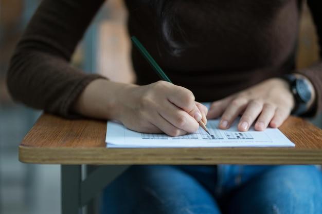 Como Estudar: 6 Segredos para Você Estudar Melhor em 2025 2 Midsection of student writing exam at desk in classroom