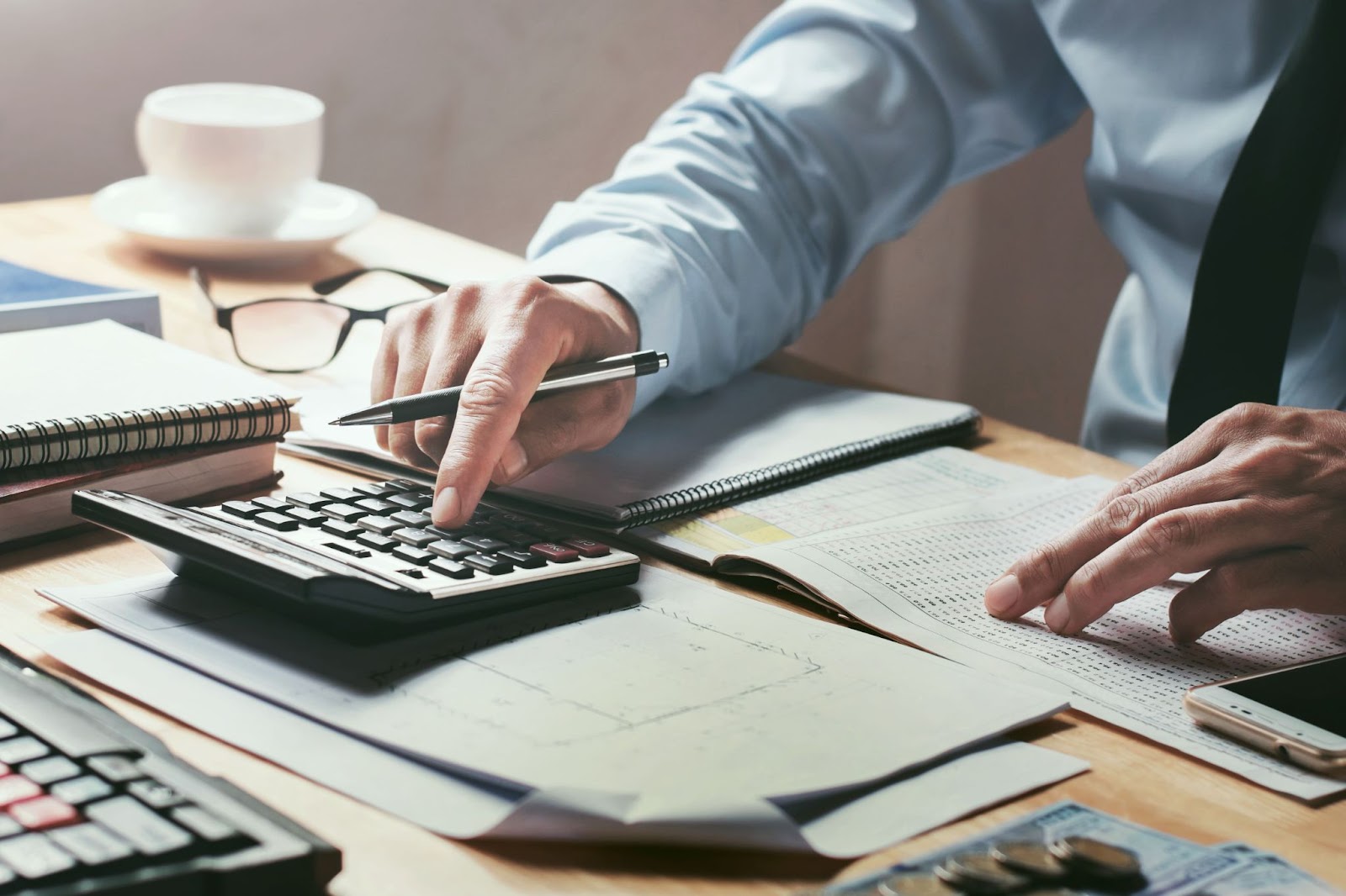 Como Usar a Inteligência Artificial? 7 Dicas Valiosas Para o Seu Negócio 5 A imagem retrata uma atividade manual de contabilidade ou análise financeira, sem indícios de tecnologia avançada como robôs, interfaces digitais complexas, ou elementos que ajudam na gestão financeira facilitada com a Inteligência Artificial.