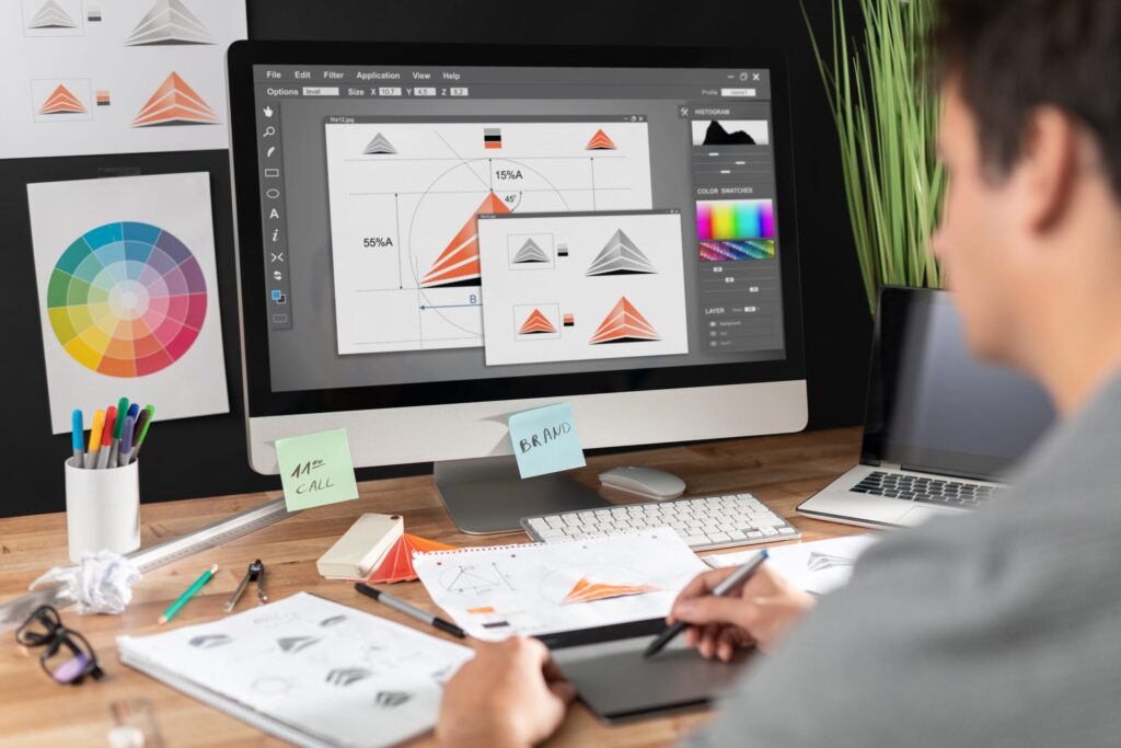 Como Usar a Inteligência Artificial? 7 Dicas Valiosas Para o Seu Negócio 6 A imagem retrata um designer gráfico trabalhando em seu computador com software de edição, utilizando uma mesa digitalizadora e outros materiais de design com a ajuda de ferramentas como a Inteligência Artificial.