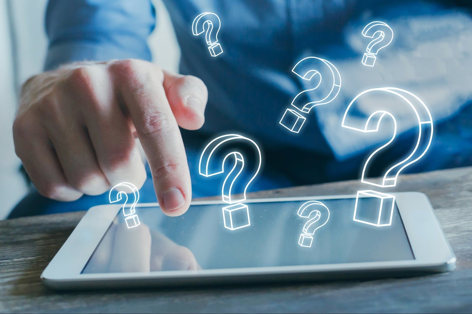 Um dedo toca a tela de um tablet, de onde saem diversas interrogações brilhantes, simbolizando a interação e as perguntas de um funil de quiz.
